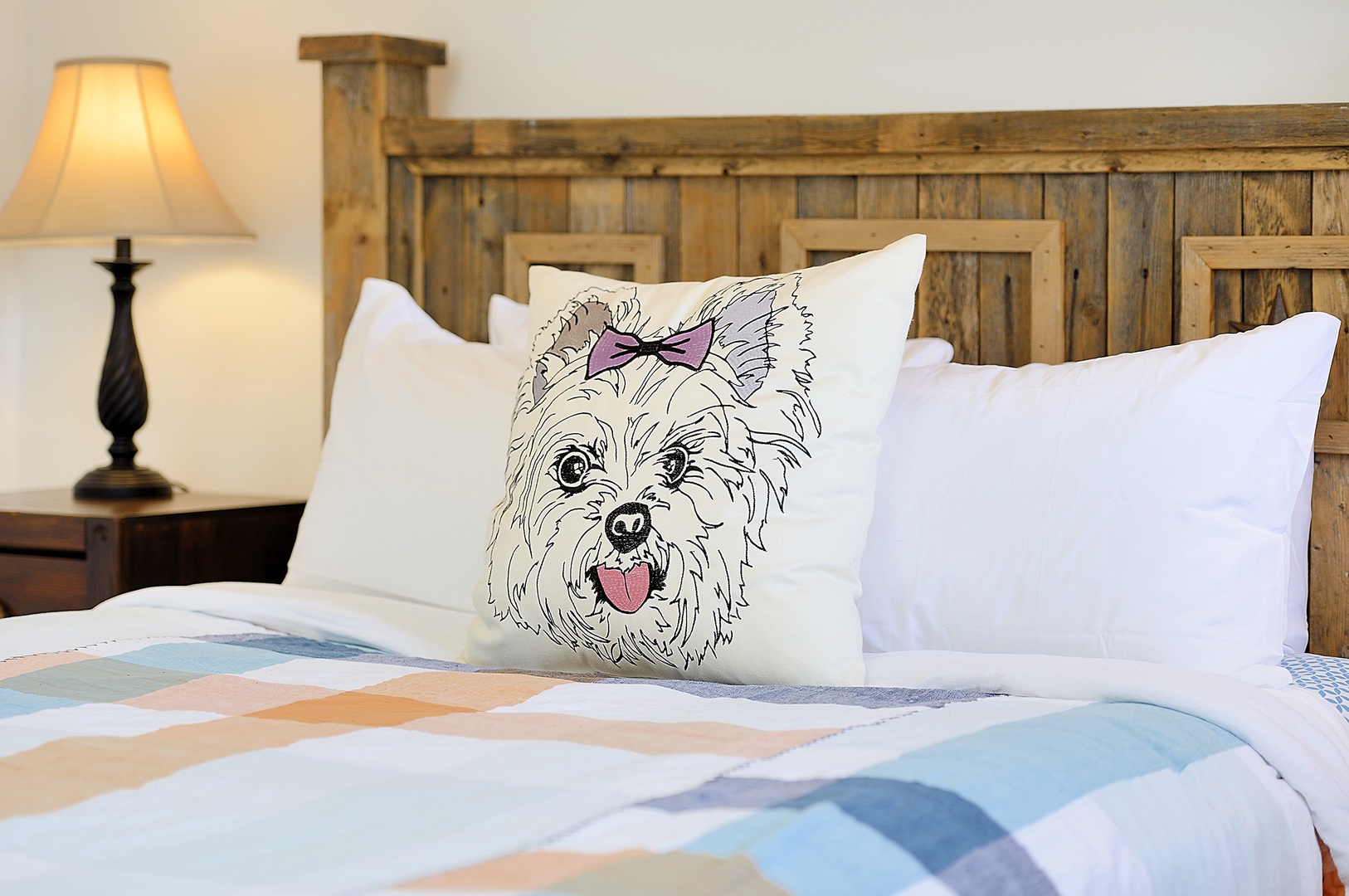 Drift off to dreamland in your cozy bedroom featuring rustic wooden headboard, plush pillows, and charming pet-themed touches.