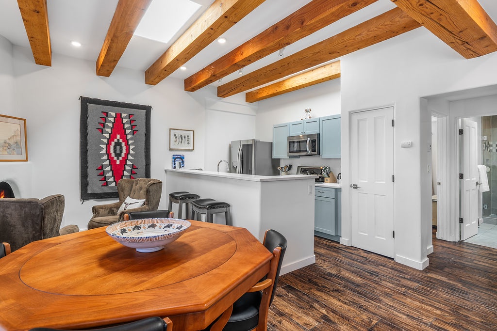 Step into your stylish open-concept haven where rustic exposed beams meet modern comfort, perfect for cooking and gathering with loved ones.