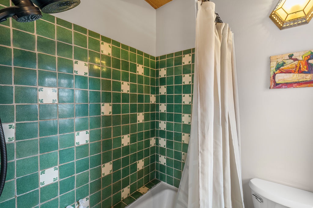 Your charming bathroom features beautiful vintage green tiles and a refreshing shower where you can unwind after exploring.