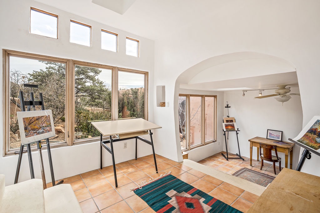 Your creative sanctuary awaits with an artist's easel, natural lighting through expansive windows, and inspiring desert views to fuel your imagination.