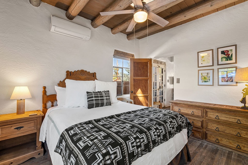 You'll love the rustic charm of exposed wooden beams overhead while crisp linens and thoughtful artwork create your perfect retreat sanctuary.