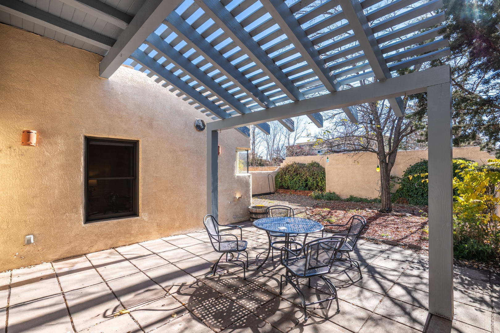 Your private covered patio offers the perfect spot to enjoy morning coffee or evening meals, with comfortable seating for six under a stylish pergola.