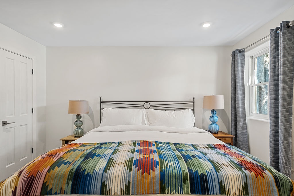 Sink into crisp white linens topped with a vibrant handwoven blanket in your peaceful bedroom sanctuary.