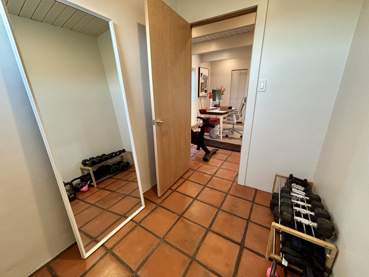 Your private workout space awaits with free weights and a full-length mirror for perfecting your form during vacation fitness sessions.