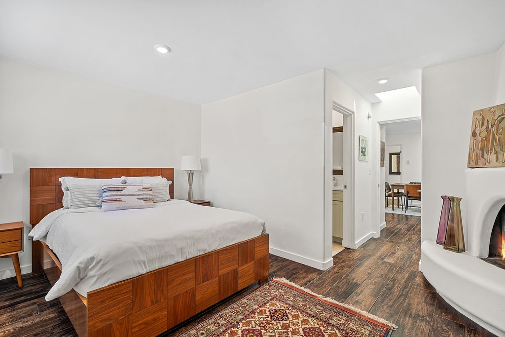 Drift off in your serene bedroom featuring warm wood furnishings, cozy fireplace, and crisp linens for ultimate comfort.