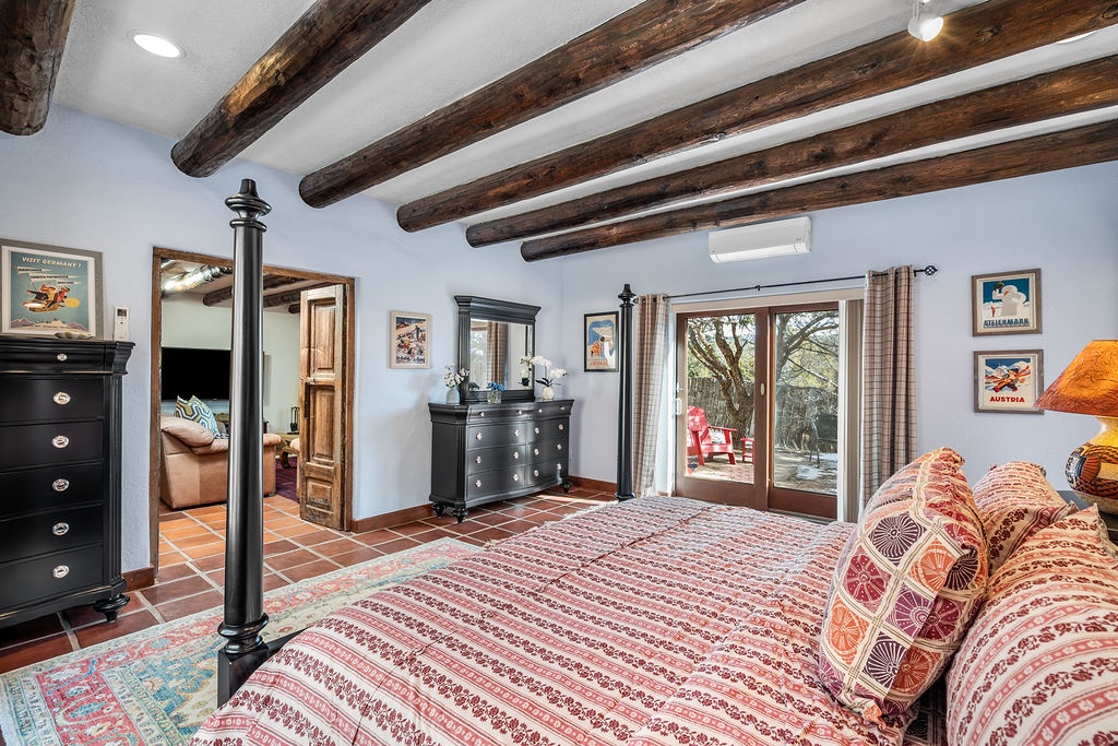 Unwind in your charming bedroom featuring rustic beams and elegant furnishings for a cozy retreat.