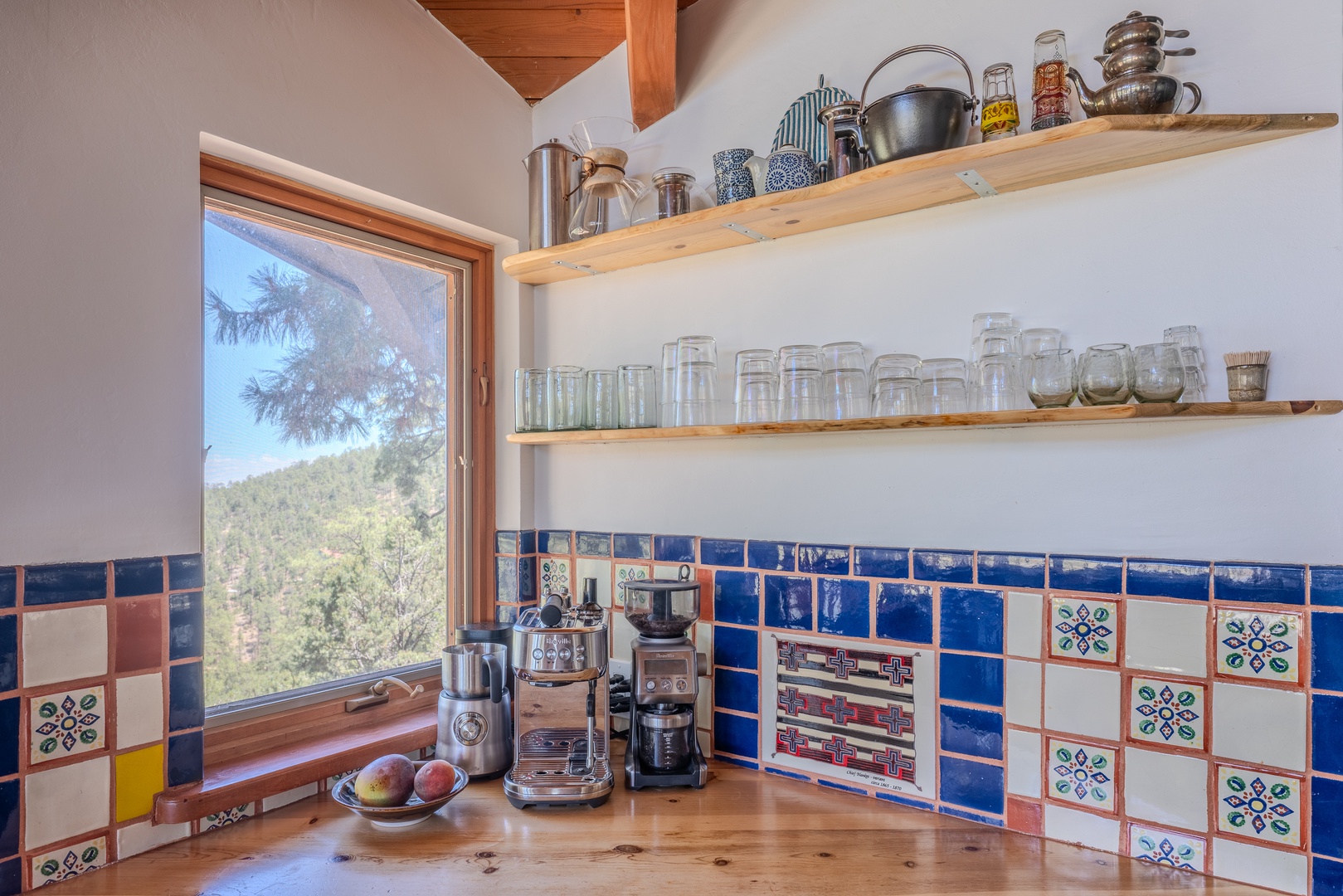 Start your mornings here with beautiful forest views framing this vibrant, handmade-tiled kitchen corner. Your coffee station awaits, where every cup feels special.