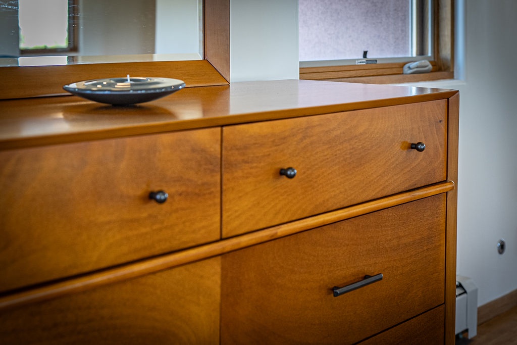 Your bedroom's elegant wooden dresser provides ample storage, topped with a stylish mirror for getting ready each morning.