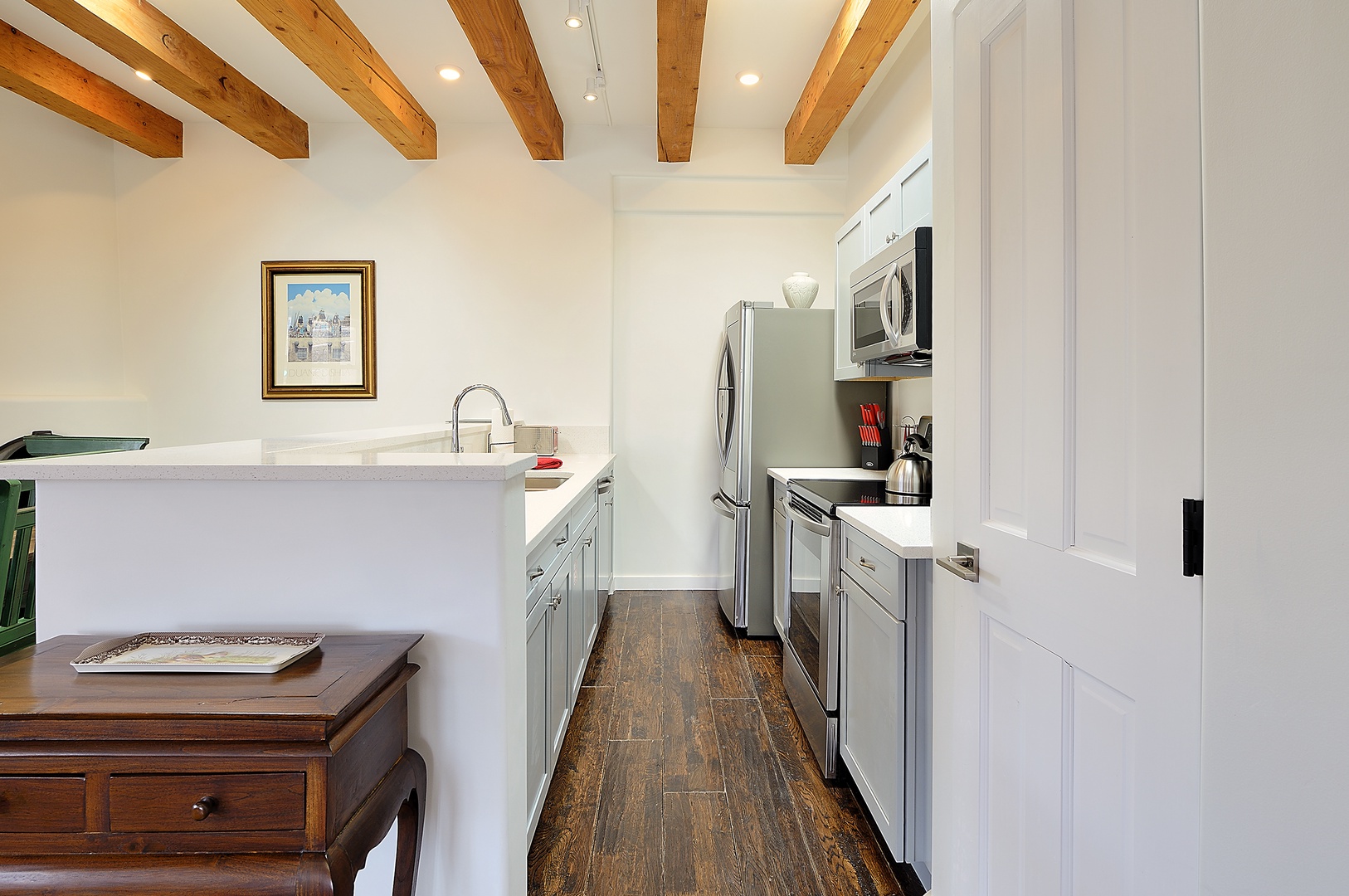 Your fully-equipped kitchen features exposed beams and modern appliances, perfect for preparing meals during your stay.