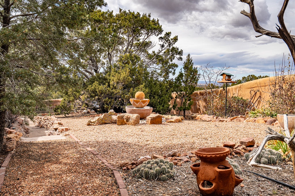 A tranquil desert garden setting with artistic pottery, native plants, and a peaceful fountain creates the perfect outdoor retreat.