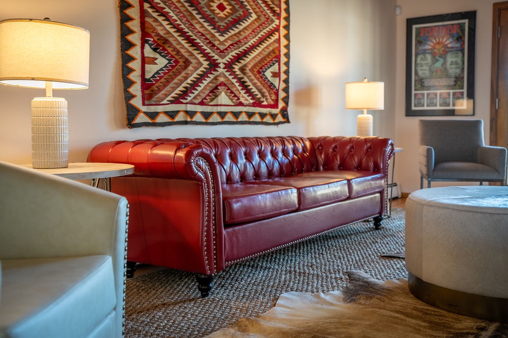 Sink into the rich leather sofa and admire the vibrant Native American tapestry while warm lighting creates your perfect evening retreat.