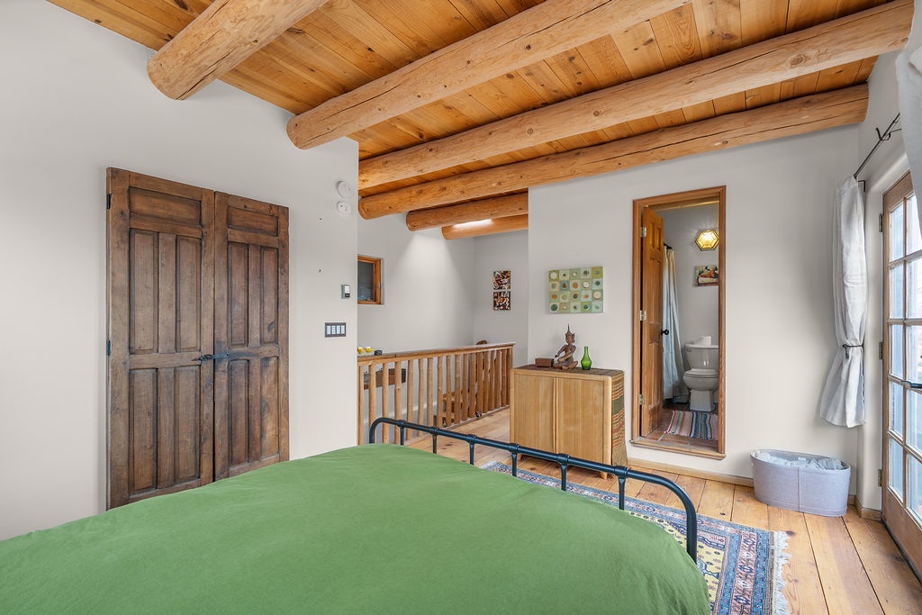 Drift off beneath stunning exposed wooden beams in your cozy bedroom, where rustic charm meets comfort with a private bathroom just steps away.