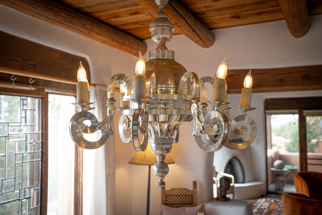 Your elegant dining space features a stunning chandelier beneath rustic wooden beams, creating the perfect ambiance for memorable meals.