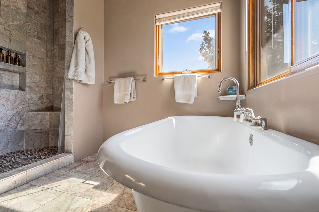 Sink into pure luxury in your private soaking tub, where marble finishes and forest views create your perfect spa escape.