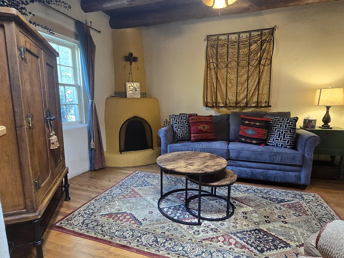 Settle into your cozy living room with a Southwestern-style kiva fireplace, rustic wood furnishings, and handwoven textiles that invite warmth and relaxation throughout your stay.