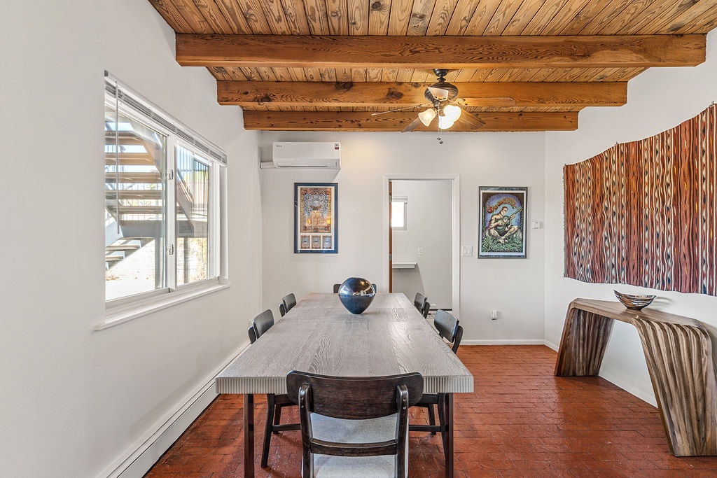 Gather around this stunning dining table beneath rustic wood beams, where your meals become memorable moments in this thoughtfully designed space.