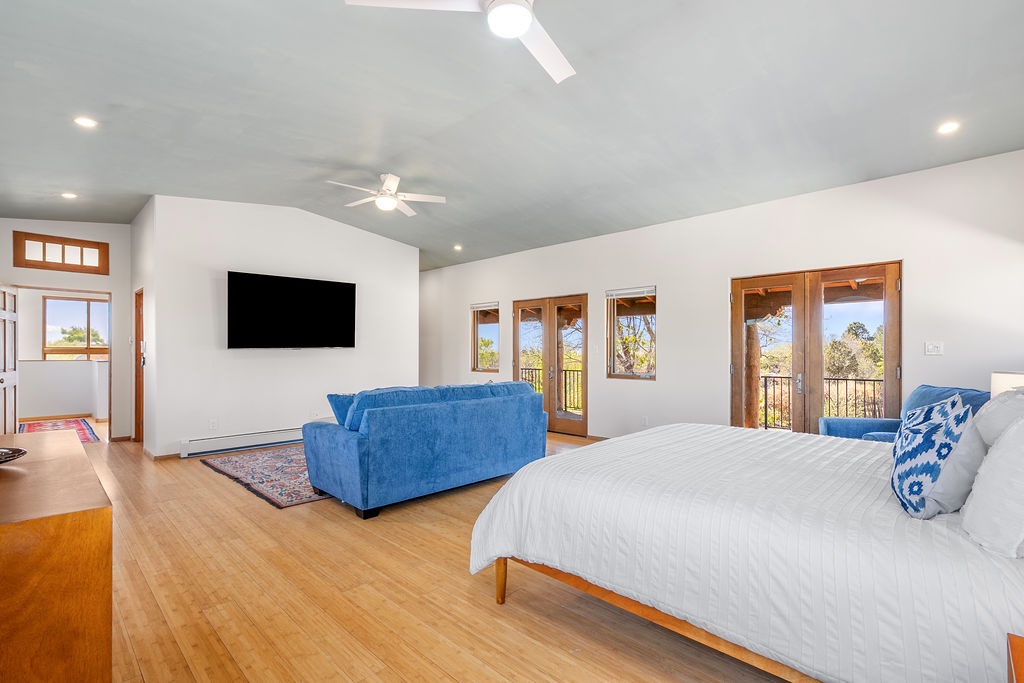 Unwind in your spacious bedroom suite with plush seating, wall-mounted TV, and French doors opening to scenic views.