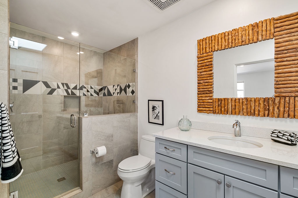 Unwind in your stylish bathroom with a spacious walk-in shower, elegant vanity, and unique bamboo mirror that adds warmth to the space.