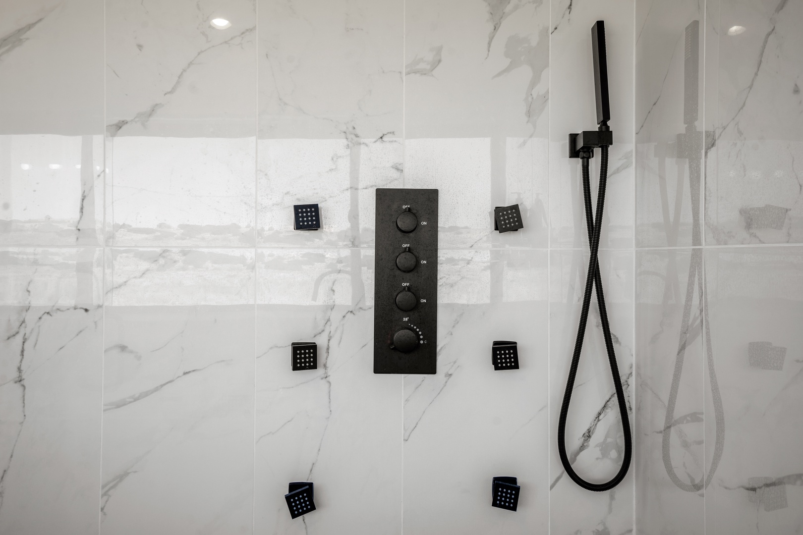 Step into your luxurious marble shower with multiple body jets and sleek controls for the ultimate spa experience.
