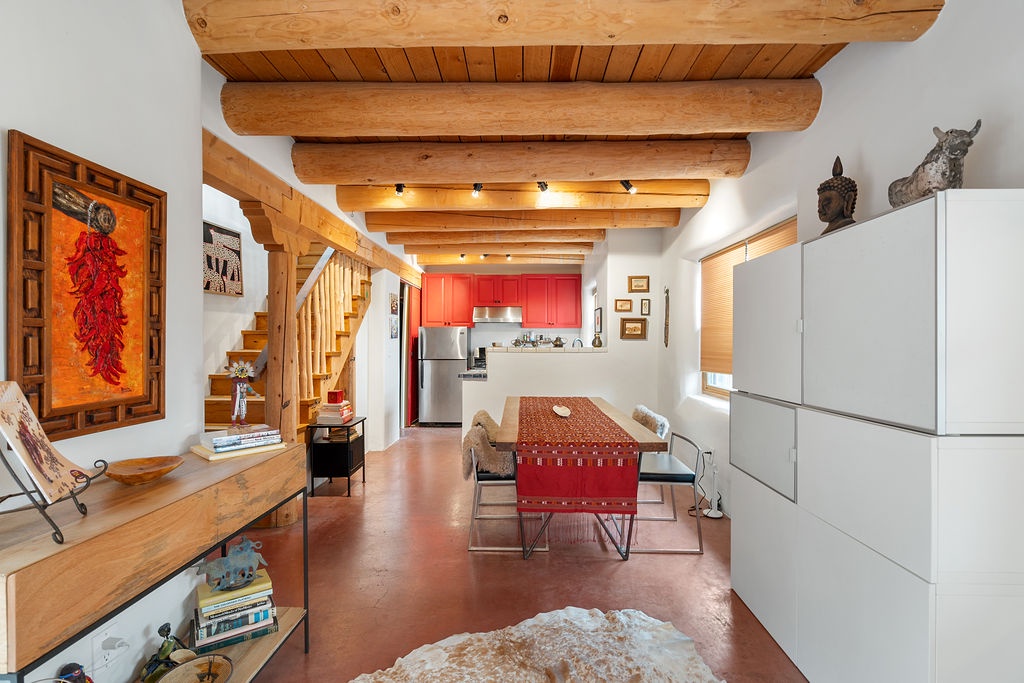 Your southwestern-style retreat features exposed wooden beams, vibrant red accents, and an open layout perfect for memorable gatherings.