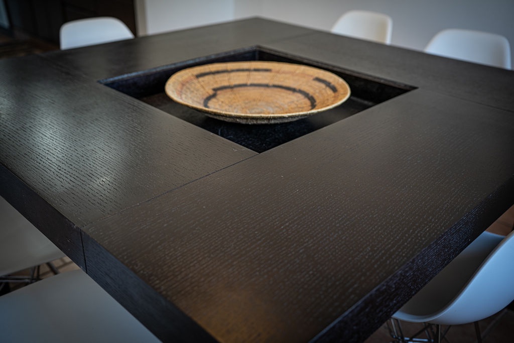 Gather around this stylish dining table where your conversations flow as beautifully as the handcrafted centerpiece bowl.