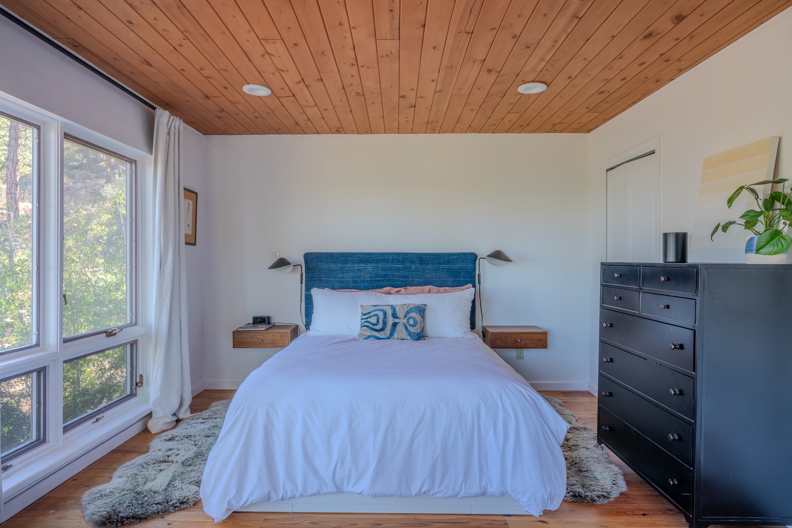 Wake up beneath warm wood ceilings and natural light streaming through your windows. Sink into plush bedding surrounded by modern comforts and serene forest views—your perfect retreat awaits.