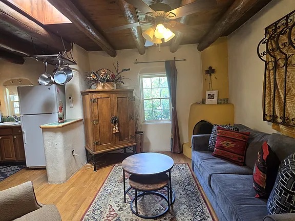 Relax in your cozy living area with vaulted wood-beam ceilings, where rustic charm meets modern comfort. The open layout connects seamlessly to the kitchen, perfect for unwinding after exploring.