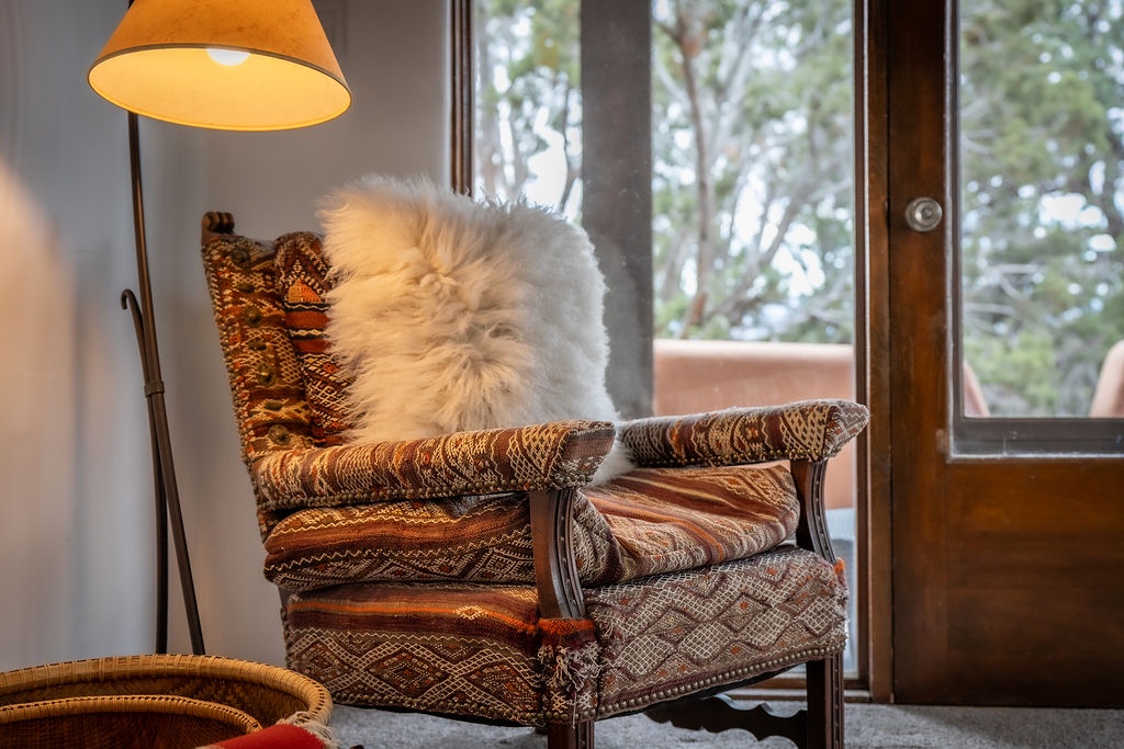 Curl up in your cozy reading nook with warm textiles and natural light streaming through the window.