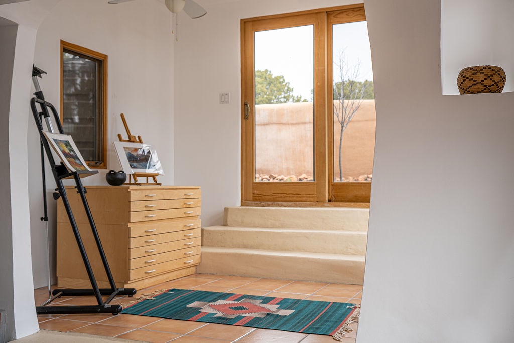 Relax in this bright artistic space with warm wood accents, vibrant textiles, and French doors opening to your private outdoor area.