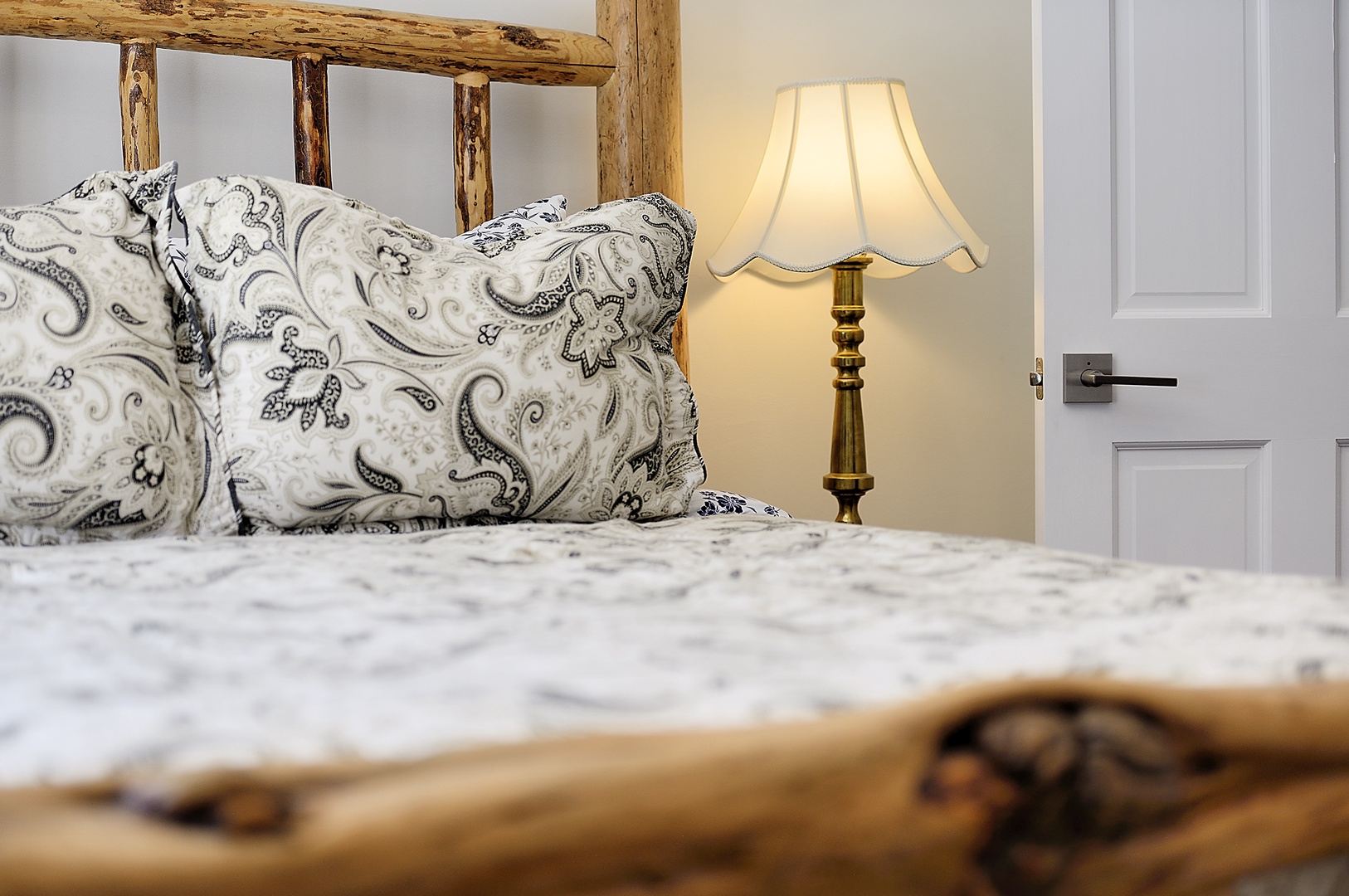 Sink into plush paisley bedding beside your warm bedside lamp in this charming rustic bedroom retreat.