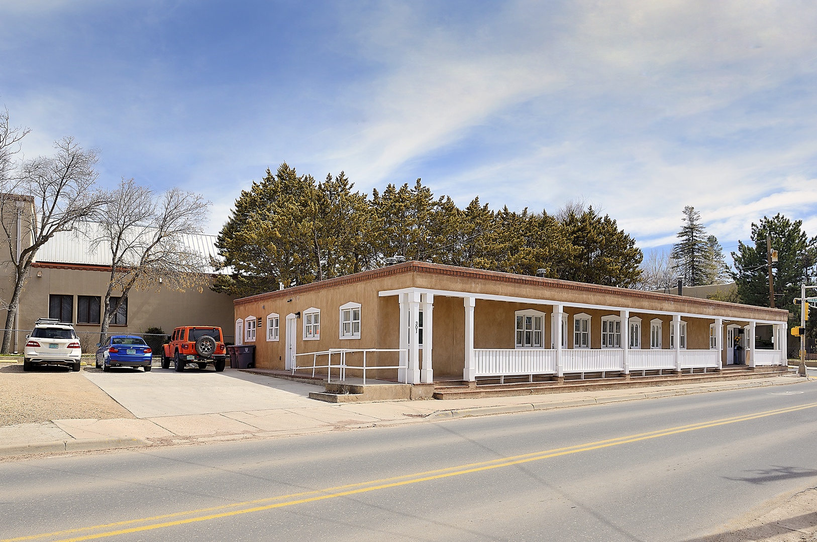 Single-story property building with classic architecture and convenient parking, situated along a quiet residential street.