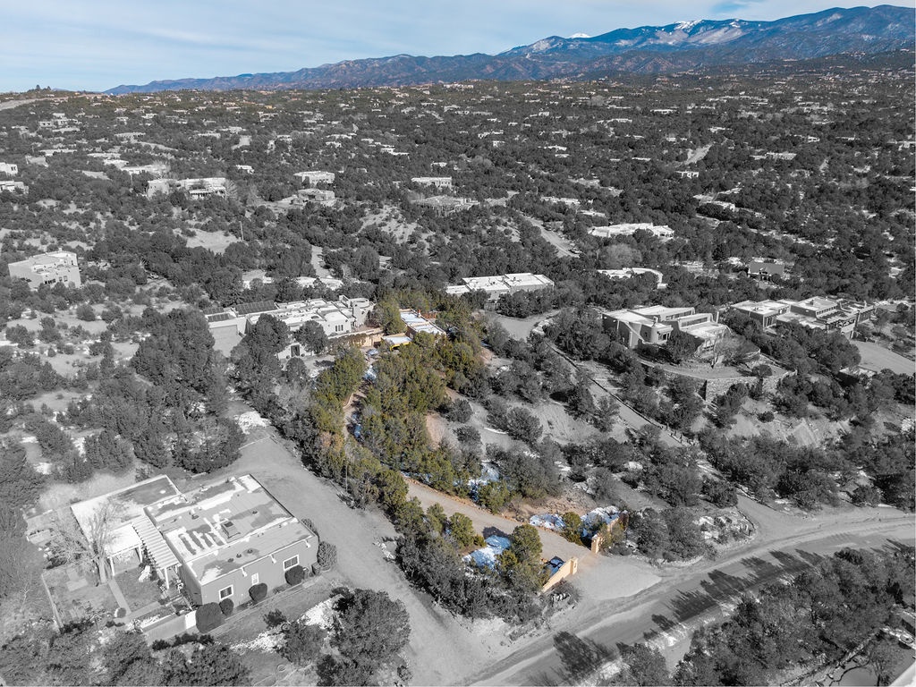 Aerial view of mountainside residential community with scattered homes nestled among natural vegetation and rolling hills.