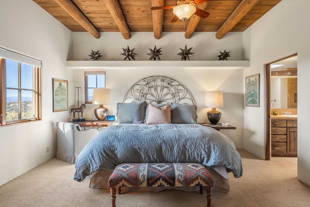 Rest beneath rustic exposed beams in your southwestern sanctuary, where handcrafted details and soft linens create the perfect retreat.