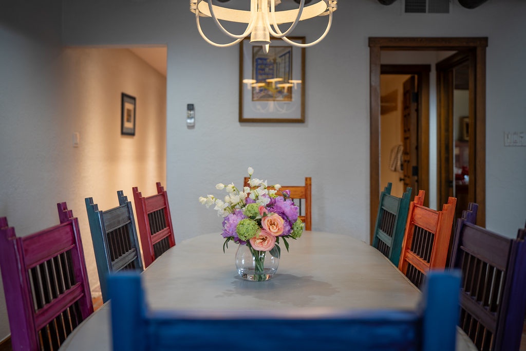Gather around this vibrant dining table where colorful chairs invite memorable meals and conversations with your travel companions.