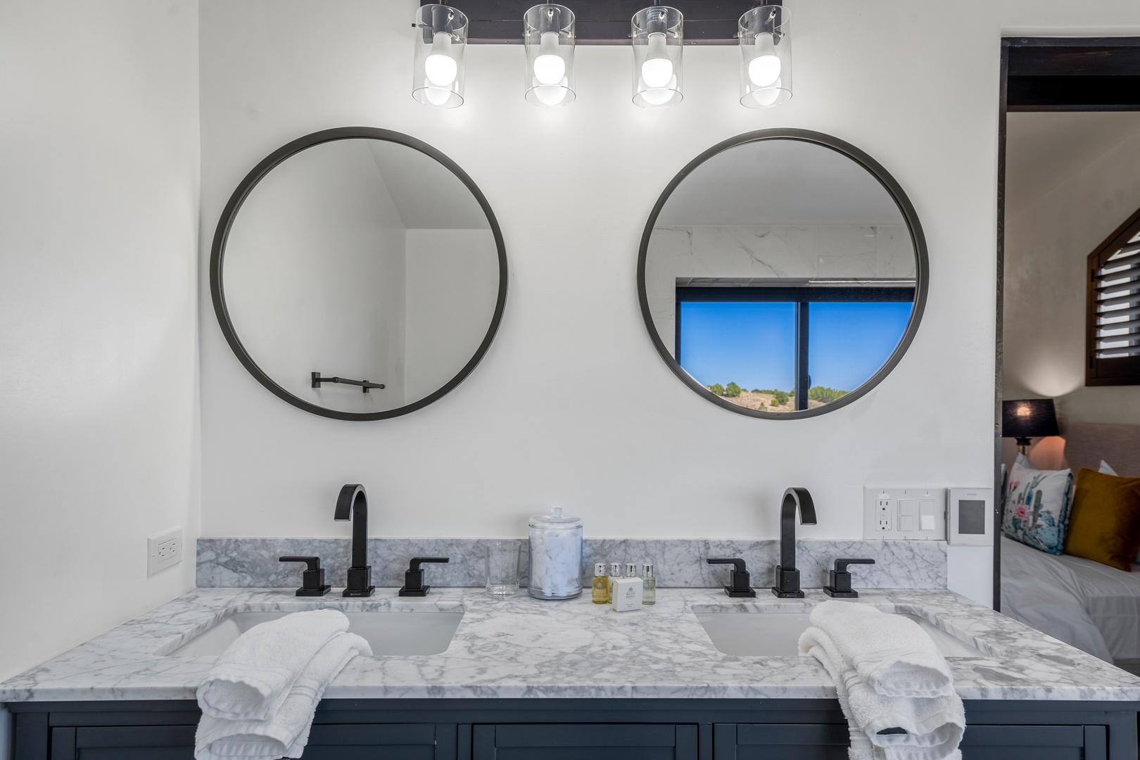 Pamper yourself at the dual vanity with marble counters, round mirrors, and plush towels for your morning routine.