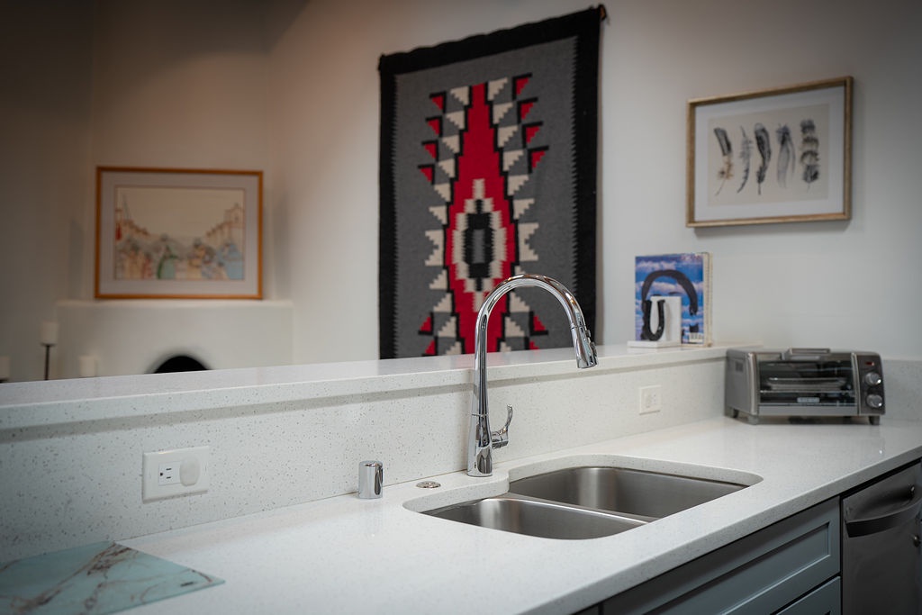 Your sleek kitchen features clean countertops, modern fixtures, and Native American artwork creating a warm, culturally rich cooking space.
