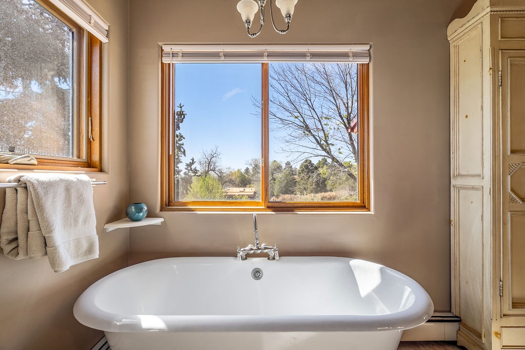 Soak in your luxurious freestanding tub while taking in peaceful countryside views through expansive windows.