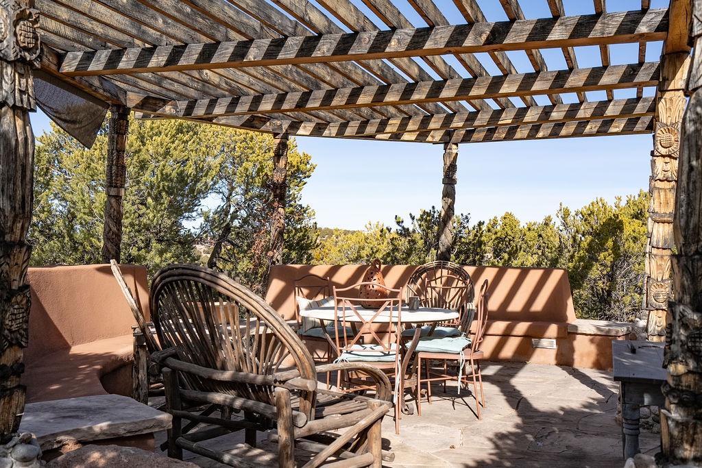Relax under your private wooden pergola with rustic seating overlooking lush trees—perfect for morning coffee or sunset dinners in peaceful seclusion.