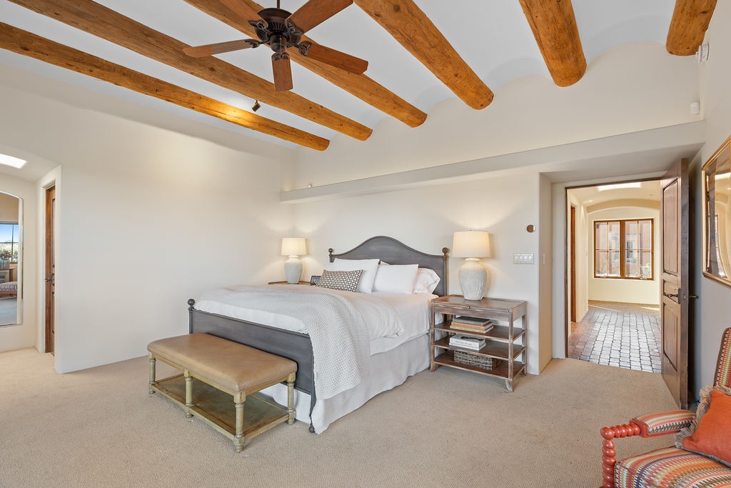 Rest beneath stunning exposed wood beams in your serene bedroom, where soft linens and warm lighting create the perfect retreat.