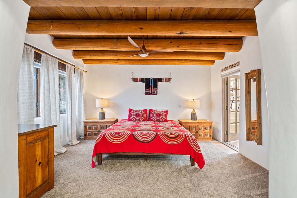 Drift off beneath stunning wood beams in your spacious bedroom, where traditional craftsmanship meets modern comfort for the perfect night's rest.