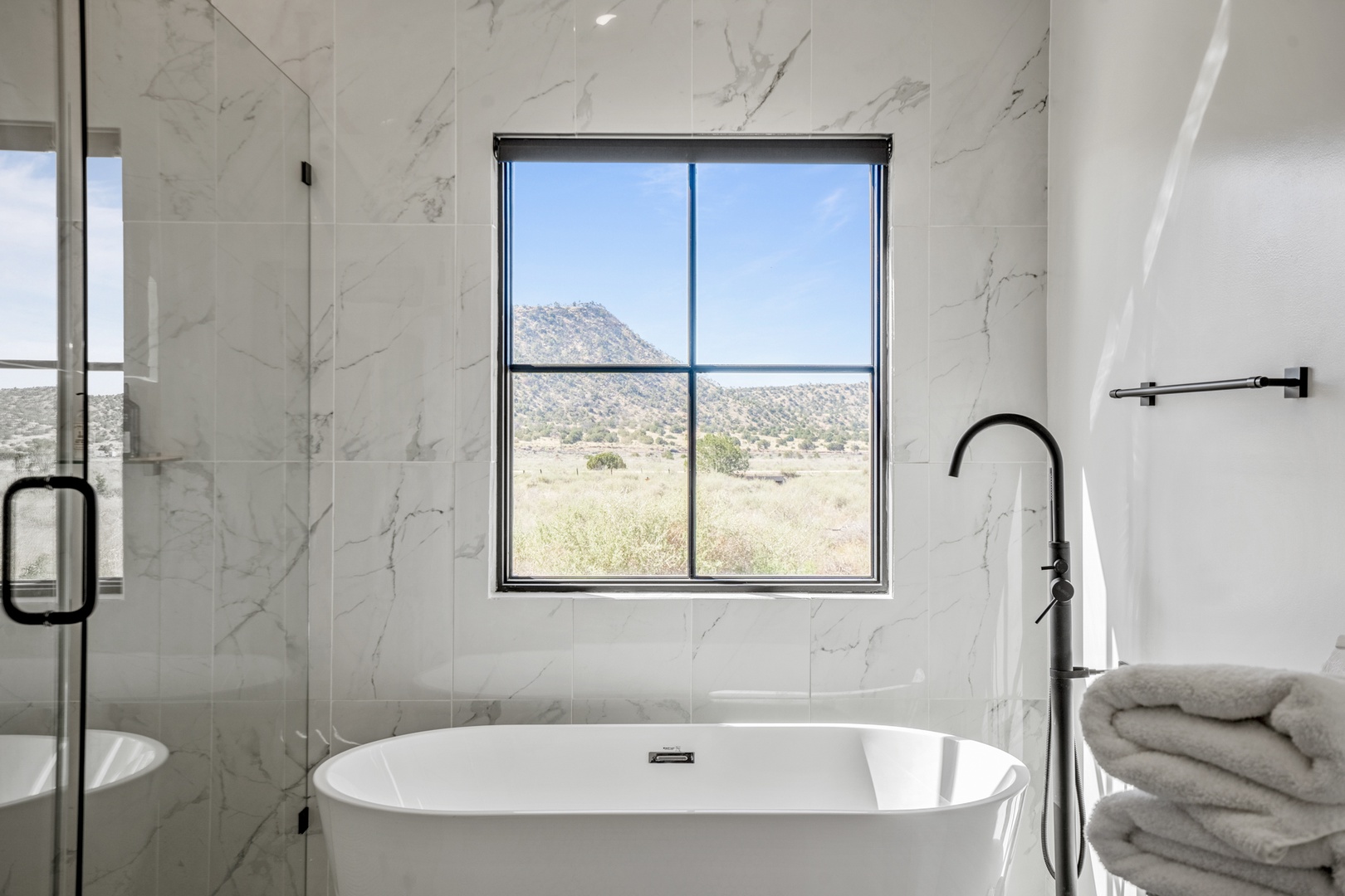 Soak in luxury as you unwind in your marble-wrapped bathroom, with stunning mountain vistas through the window creating the perfect backdrop for relaxation.