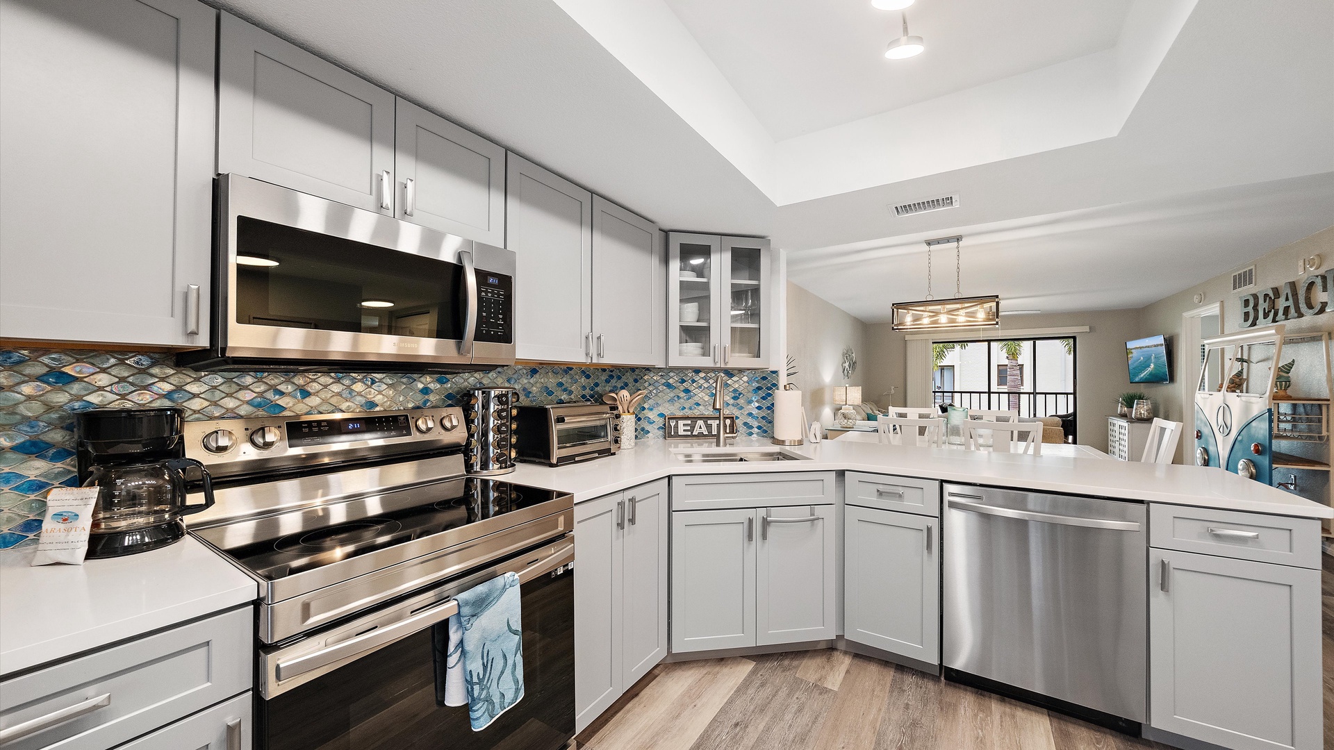 Step into your bright, beachside kitchen where coastal charm meets modern convenience. Cook up vacation memories with stainless steel appliances, elegant white countertops, and a playful turquoise backsplash that brings the ocean right inside.