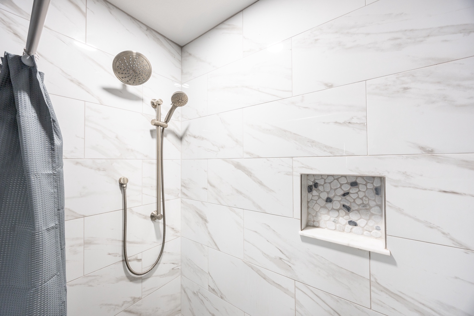 Step into your spa-like marble shower featuring dual rainfall heads and elegant brass fixtures for the ultimate relaxation.