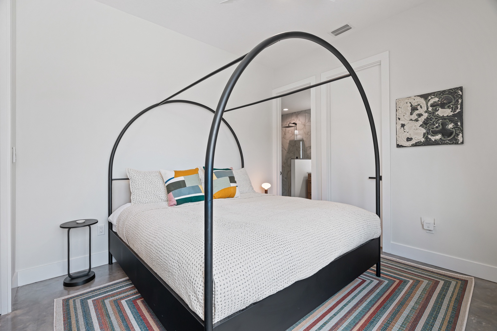 Drift into restful slumber beneath striking curved arches in your serene bedroom. Colorful accent pillows pop against crisp white bedding, while soft lighting creates the perfect ambiance.