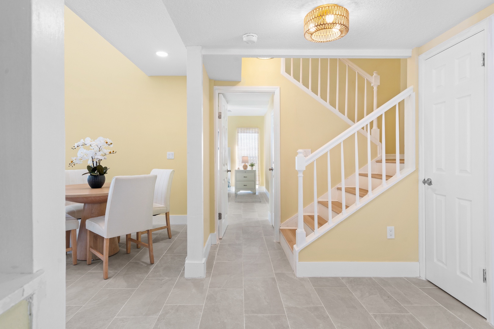Your bright, welcoming entryway flows seamlessly into elegant dining space with modern touches and warm lighting.