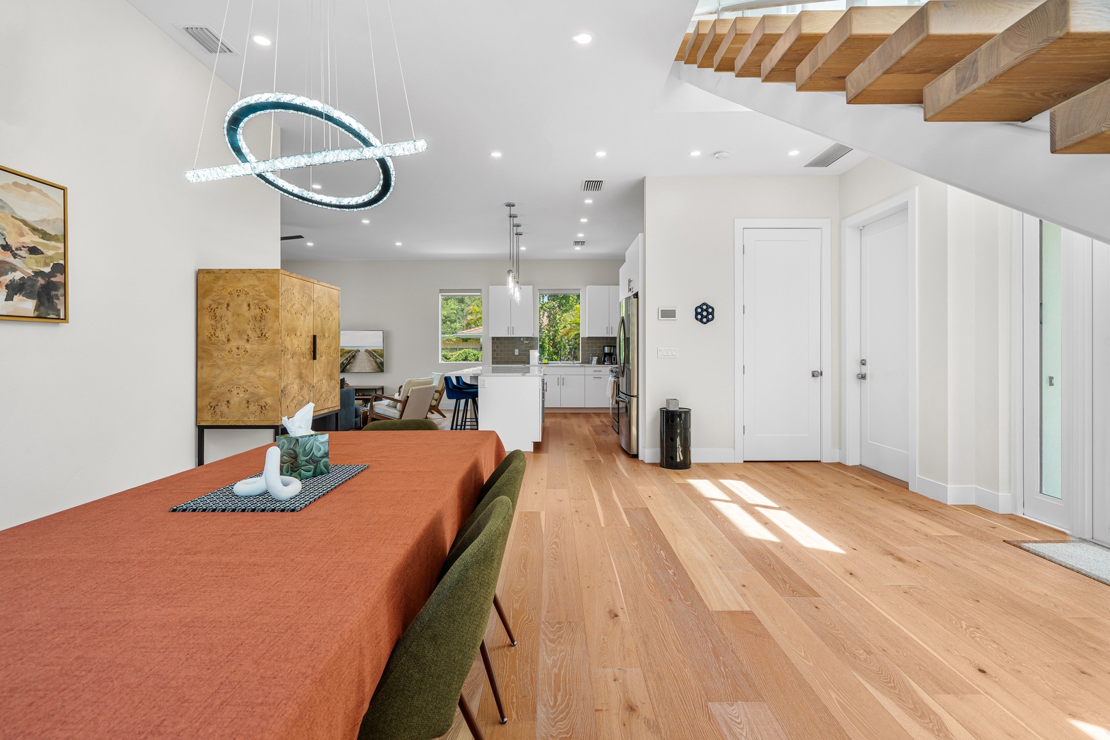 Step into your modern retreat bathed in natural light. Warm wood floors flow beneath soaring ceilings, connecting your open living space to a sleek kitchen perfect for morning coffee or evening meals.