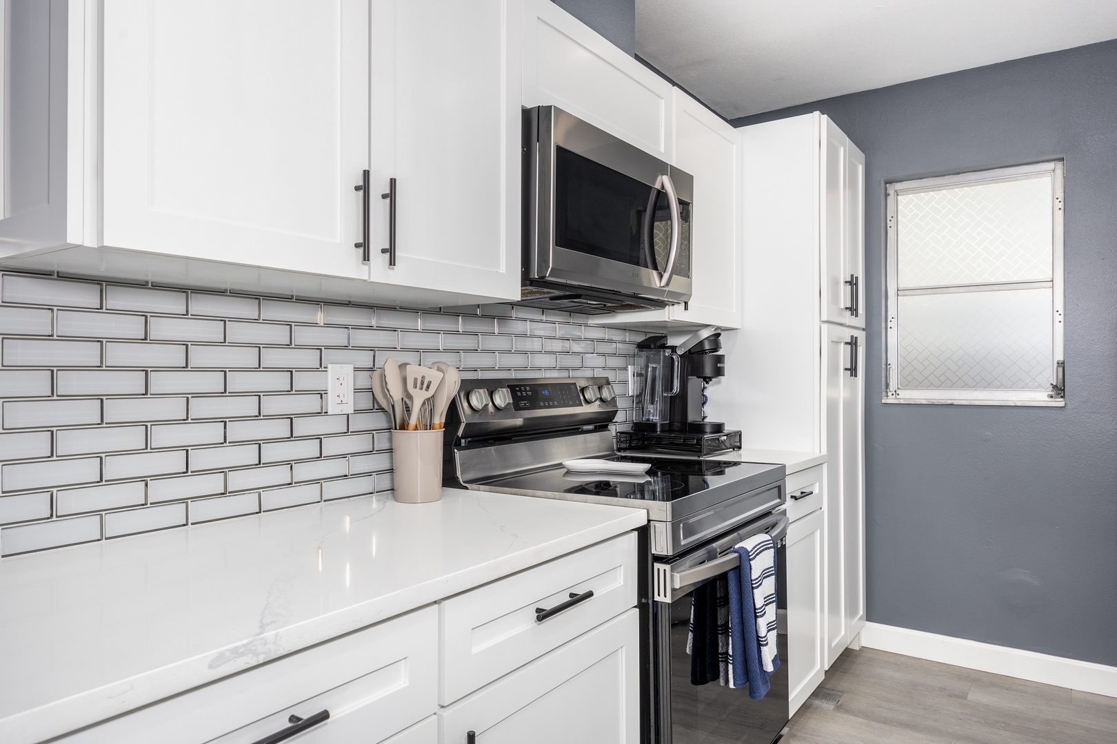 Cook with ease in this modern kitchen featuring stainless steel appliances, sleek white cabinets, and stylish subway tile backsplash.