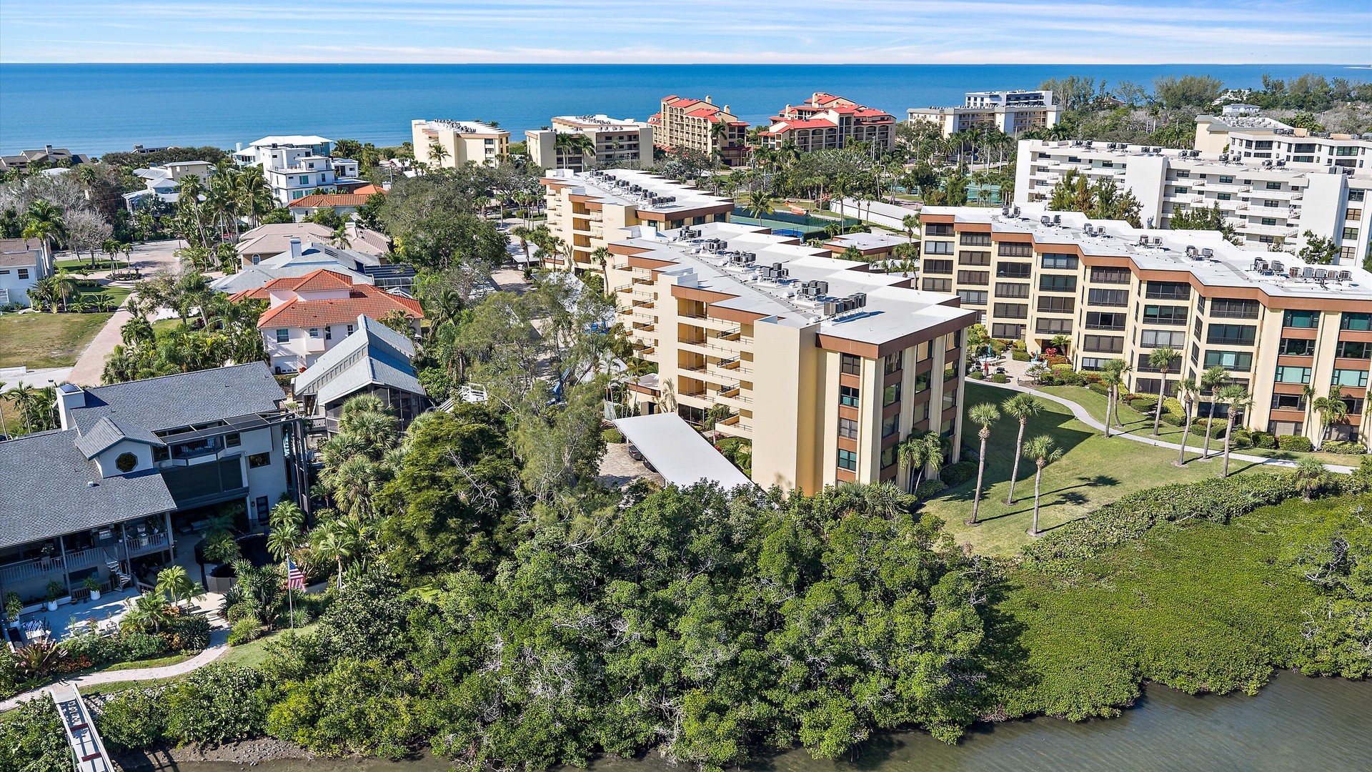 Aerial view of the resort complex and surrounding coastal community with hotels, condominiums, and tropical landscaping near pristine beaches.