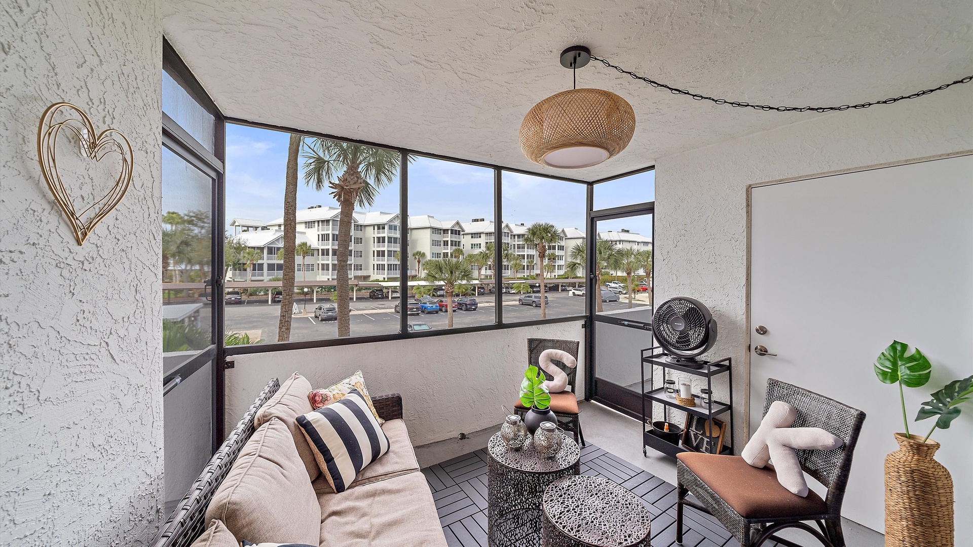 Relax in your bright, airy living space with panoramic windows that fill the room with natural light and showcase views of palm trees and the surrounding area.