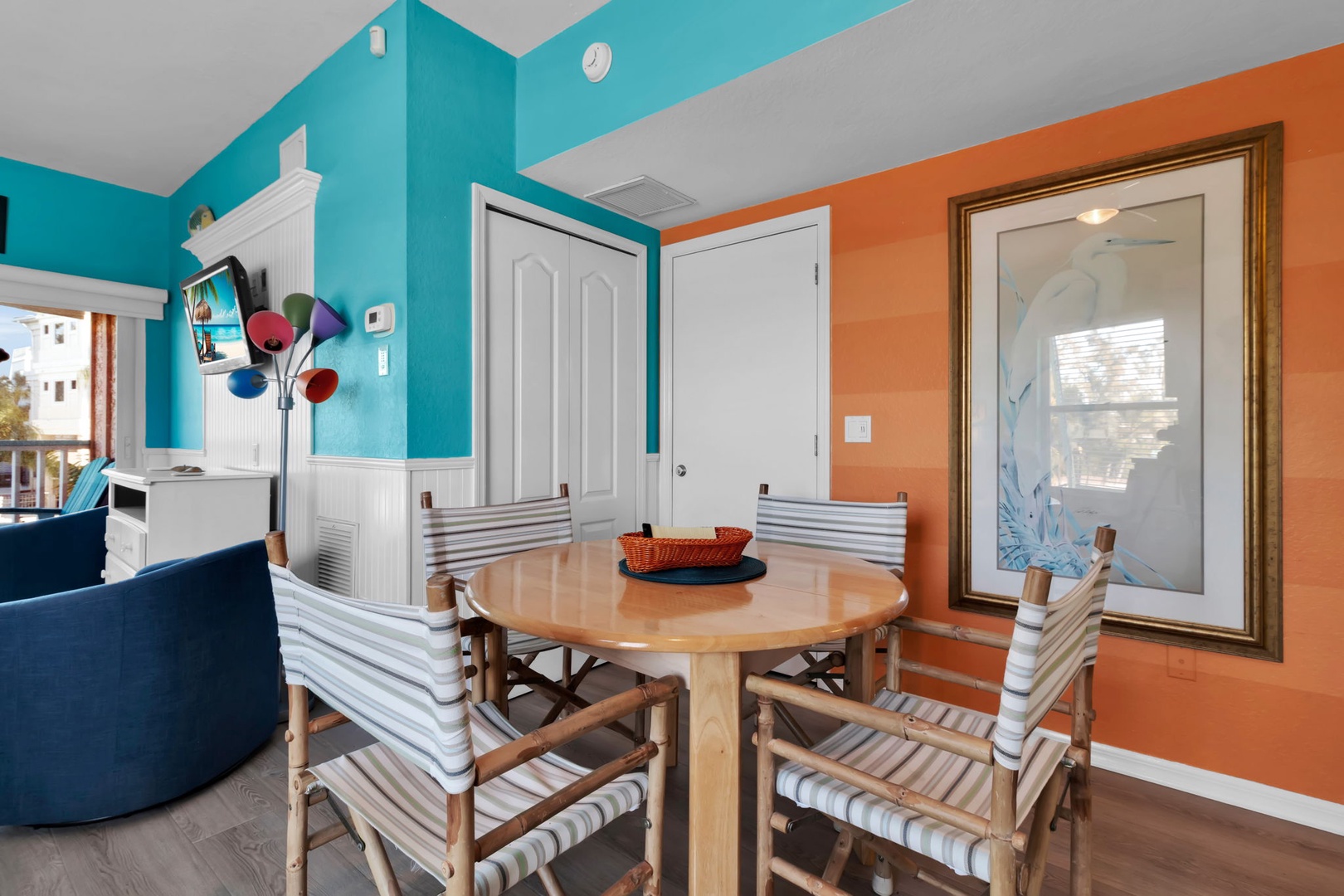 Vibrant turquoise and warm coral walls create a cheerful dining space where you'll savor morning coffee or evening meals around the inviting round table.